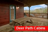 Cabin with picnic table and hot tub on deck