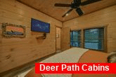 Master bedroom with TV and bath in resort cabin