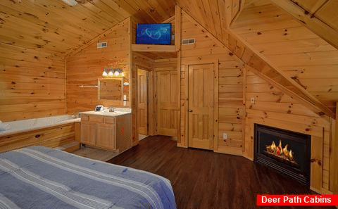 King bedroom with fireplace and jacuzzi in cabin - Fishin Hole